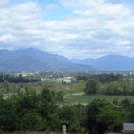 A scenic view of the Chilliwack valley with mountains and farmland